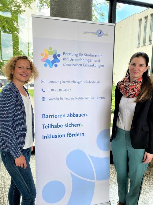 Katrin Fischer (links) und Anja Ahrens (rechts) stehen neben dem Rollup der Beratungsstelle bei den inFUtagen 2022