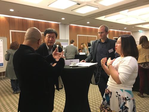 HUANG Liaoyu, der ZeDES-Direktor Nyuri Kim aus Seoul, Benjamin Langer und Doktorandin ZENG Yue im Gespräch vor Frau Zengs Poster.