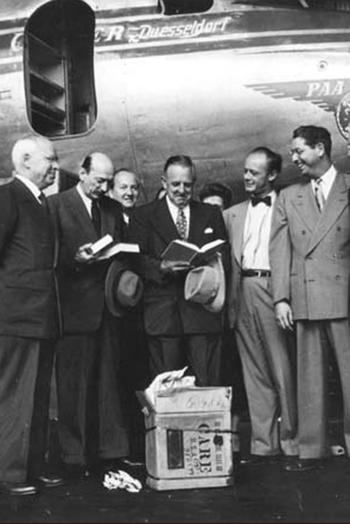 Auf dem Flughafen Tempelhof übergibt Paul G. Hoffman, Präsident der Ford Foundation, dem Rektor der Freien Universität, Freiherr von Kreß, die erste Sendung von 20.000 Büchern, die die American Brotherhood insgesamt sammeln wird.