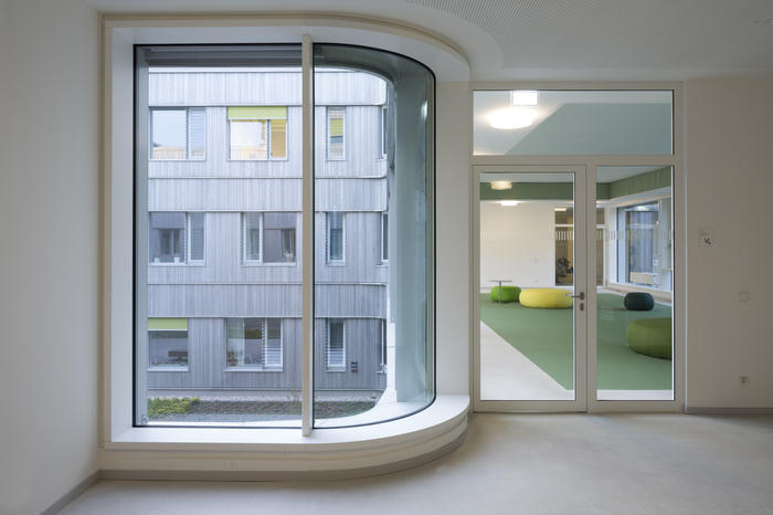 Der Neubau für die Kleinen Fächer mit gerundetem Fensterelement und Blick in einen Aufenthaltsraum.